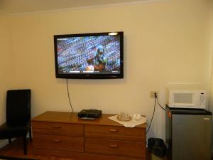 a flat screen tv on a wall in a hotel room at Twin Oaks Motel in Manasquan