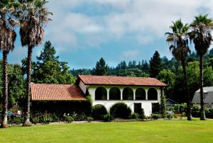 a house with a red roof and palm trees at Spanish Villa Inn in St. Helena