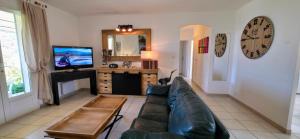 ein Wohnzimmer mit Sofa und Fernseher in der Unterkunft Gîte Nidu, un coin de paradis Provençal in Le Barroux