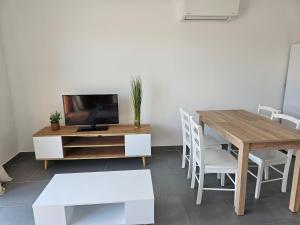 a living room with a wooden table and a tv at L'Ardèchois in Saint-Remèze