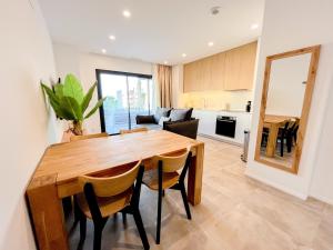 a kitchen and dining room with a wooden table and chairs at El Campello Ocean View Escape in La Venteta