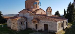 an old church with a clock tower on top of it at Among the trees and by the sea in Fier +17 photos