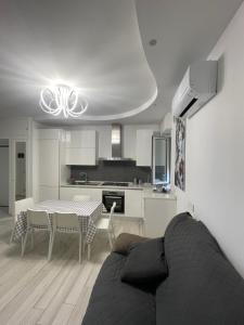 a kitchen and a living room with a couch and a table at Appartamento Lindo e Dora - A due passi dal mare in San Benedetto del Tronto