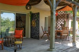 a screened in porch with chairs and a table at Les gardiens de la vallée in Figeac