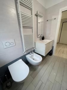 a white bathroom with a toilet and a sink at Appartamento Lindo e Dora - A due passi dal mare in San Benedetto del Tronto