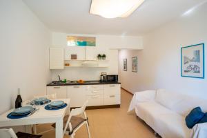 ein Wohnzimmer mit einer weißen Couch und einem Tisch in der Unterkunft GuestHost - Modern Escape with Pool & Sunny Terrace in Sanremo