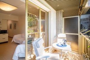Zimmer mit einem Balkon mit Tisch und Stühlen in der Unterkunft GuestHost - Modern Escape with Pool & Sunny Terrace in Sanremo