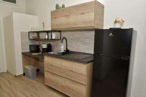 a kitchen with a black refrigerator and wooden cabinets at miem's home in San Giuseppe Vesuviano