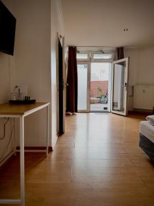 a living room with a wooden floor and a table at Erlanger Hof in Berlin +62 photos