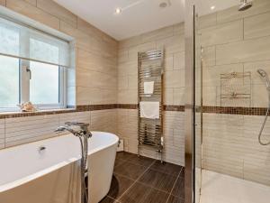 a bathroom with a tub and a glass shower at 4 Bed in Braunton 78250 in Braunton +37 photos