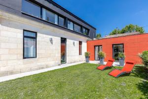 two red chairs sitting on a lawn next to a building at La villa d'Alix in Bègles