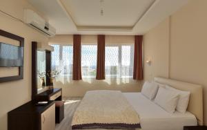 アンタルヤにあるNurella Pansiyonのベッドとテレビが備わるホテルルームです。