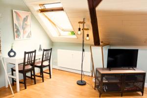Weyheにあるunique - maisonette - kitchen - parking - cozy - washing machineのテレビとテーブルと椅子のあるリビングルーム