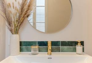a bathroom sink with a mirror above it at Le Nid des Chartrons - Suite privée élégante au cœur de Bordeaux in Bordeaux
