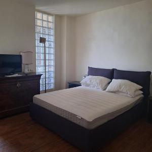 una camera con un grande letto e una TV su un tavolo di B&B 47 a Loano