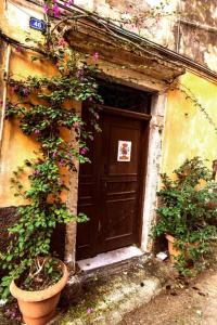 une porte d'un bâtiment avec des fleurs devant dans l'établissement Summer Me - Corfu Downtown Studios, à Corfou