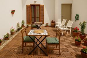 a patio with a table and chairs and plants at Nicolas Beach in Palaiochora