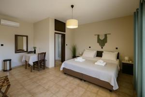 a bedroom with a large white bed and a table at Nicolas Beach in Palaiochora