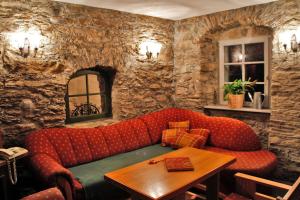 a living room with a red couch and a table at Ferienhaus zum Grünen Hirsch Stolln in Breitenbrunn +3 photos