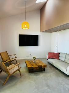 a living room with a couch and a table at La Casa M-maison idéale pour groupes familles amis 12 personnes au calme avec piscine in Sainte-Hélène