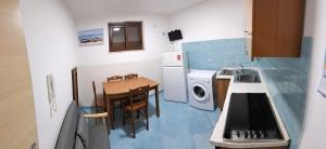 a small kitchen with a table and a washing machine at Monolocale centro!! in Palinuro +5 photos