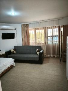 een woonkamer met een bank en een bed bij Vila Marius-camere de închiriat in Eforie Nord