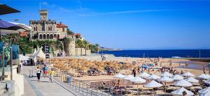 a beach with umbrellas and people on the beach at THE Estoril Studio in Estoril