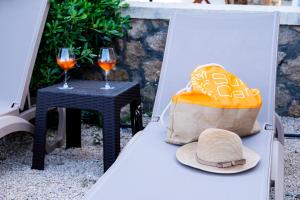 ein Hut und ein Tisch mit zwei Gläsern Wein in der Unterkunft Villa Sunrise by the Sea in Kiotari