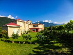 ein Haus auf einem Hügel mit Bergen im Hintergrund in der Unterkunft Mei Jung B&B in Zhixue