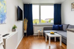 ein Wohnzimmer mit Sofa und Tisch in der Unterkunft Taikos STUDIO Apartamentai-2 in Klaipėda