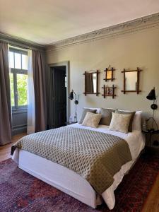 1 dormitorio con 1 cama grande y 2 espejos en la pared en Les Villas du Parc, en Vittel