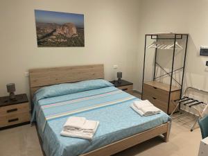 a bedroom with a bed with two towels on it at maraneri rooms in Bovalino Marina