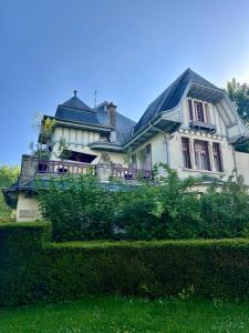una gran casa blanca con techo negro en Les Villas du Parc, en Vittel