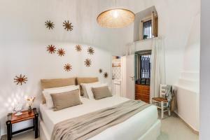 een slaapkamer met een groot wit bed met sneeuwpoppen aan de muur bij U Quardianu - Le Case di Valentina in Gallipoli