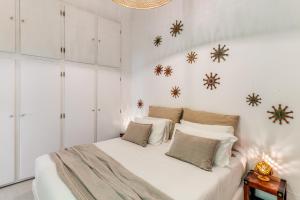 een slaapkamer met een wit bed met sneeuwvlokken aan de muur bij U Quardianu - Le Case di Valentina in Gallipoli