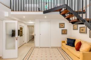 een woonkamer met een bank en een trap bij U Quardianu - Le Case di Valentina in Gallipoli