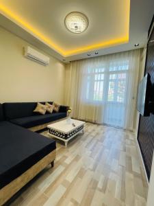 Una sala de estar con un sofá y un televisor. en Amora Suites, en Estambul