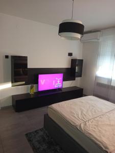 een slaapkamer met een bed en een flatscreen-tv bij Aurora in Zagreb