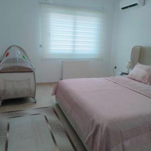 a bedroom with a large bed and a window at Chez Lina Folla in Monastir