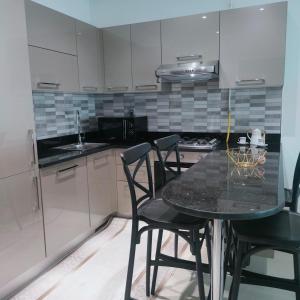 a kitchen with a black table and chairs in it at Chez Lina Folla in Monastir