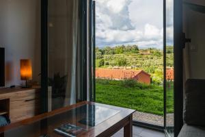 a room with a glass table and a large window at Perla Vera - Country Modern Apartment in Villanueva de la Vera