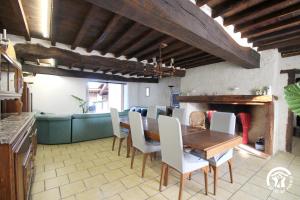 a dining room with a table and a fireplace at La maison du village in Bajonnette