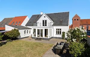 LøgstørNice Home In Løgstør With Wifi的一栋带有黑色屋顶的白色房子