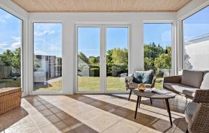 LøgstørNice Home In Løgstør With Wifi的带窗户、沙发和桌子的客厅