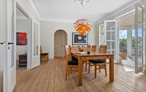 LøgstørNice Home In Løgstør With Wifi的一间有桌椅和枝形吊灯的餐厅