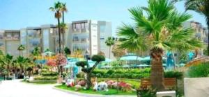 a park with palm trees in front of a building at Chez Lina Folla in Monastir