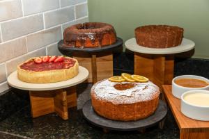 a group of cakes on plates on a table at Slaviero Hotel Curitiba Shopping in Curitiba +86 photos