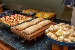 a buffet of bread and pastries on a counter at Slaviero Hotel Curitiba Shopping in Curitiba