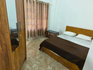 a bedroom with a bed and a window at Josco Residency Karthikapuram in Paithalmala