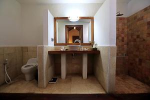 a bathroom with a sink and a toilet and a mirror at Laguna Gili in Gili Trawangan